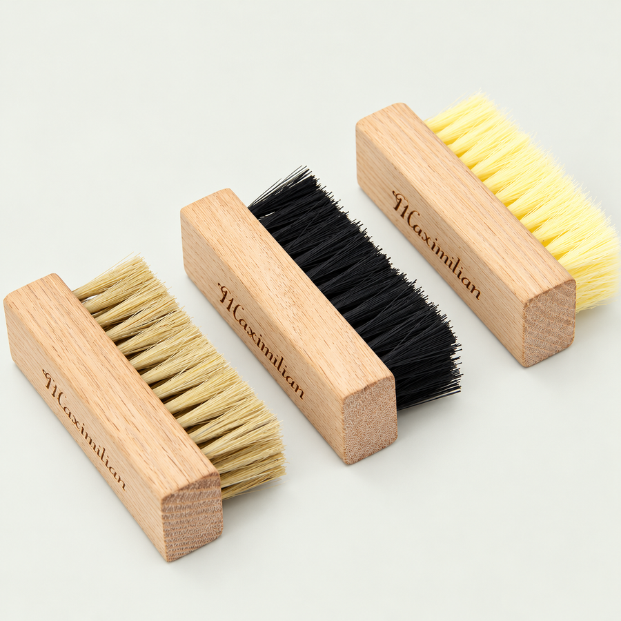 Three wooden-handled trainer brushes with natural, black and yellow bristles
